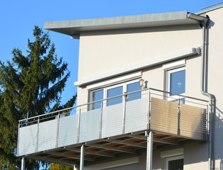 Moderner Balkon mit Edelstahl-Geländer und Edelstahl-Sichtschutzplatten an Neubau-Hausfront