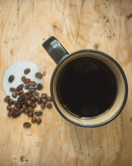 cup of coffee and beans on wooden table