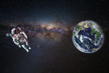 Astronaut in outer space over of the Earth with sun light. City lights on planet. Elements of this...