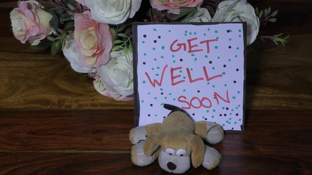 Get well soon card with flowers and small soft toy dog