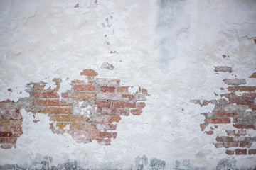 white brick wall with peeling stucco