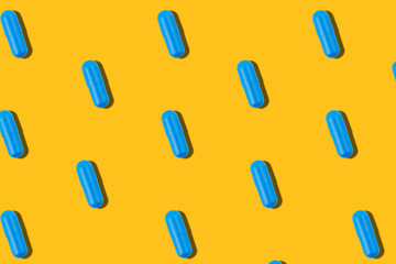 Seamless pattern with blue pills on a yellow background.