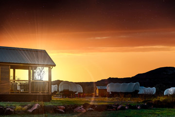 The sun setting behind a cabin building at an empty campsite near Fruita, Utah, USA in Capitol Reef National Park. 