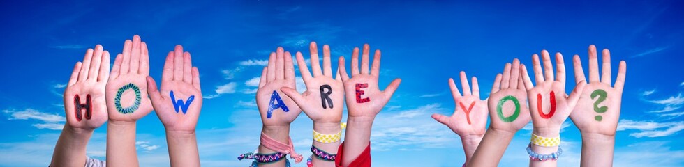 Children Hands Building Colorful English Word How Are You. Blue Sky As Background