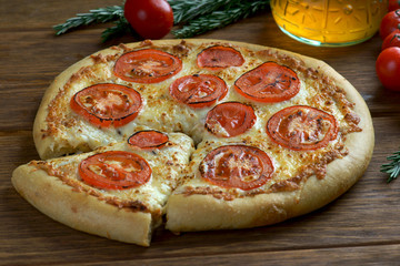 pizza Margarita with tomatoes on a wooden background