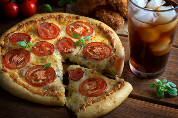 pizza Margarita with a glass of Cola and chicken wings on a wooden background