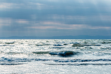 Fototapeta na wymiar Sea surf with waves in beautiful sunlight