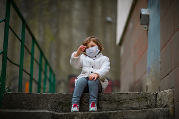 Fototapeta premium little girl on a walk in a medical mask