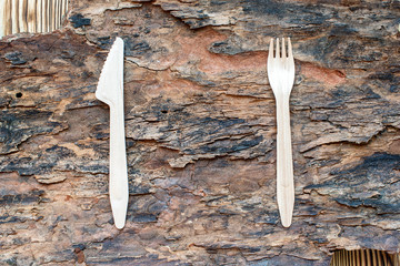 wooden cutlery on a piece of wood bark. eco-friendly knife with a fork on a wooden background....