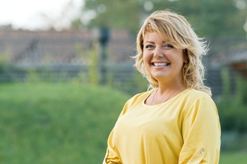 Outdoor portrait successful mature woman blonde in yellow dress - Powered by Adobe