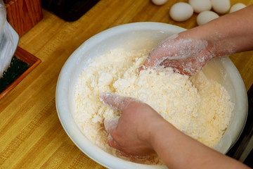 Woman mixing flour and cheese for making cheese bread dough .