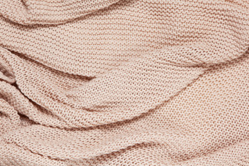 Textured surface of knitted cotton wave plaid, top view. Soft dusty pink pastel wool backdrop. Seasonal cosiness flat lay. Scandinavian minimal style. Stay at home, cozy, femininity concept