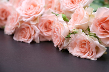 Fresh pink roses on a black background made of natural stone. Copy space