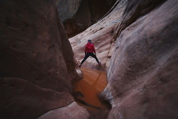 Adventurous Active Female Exploring Red Rock Sandstone Slot Canyon