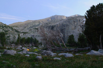 High elevation campsite next to lake with shear granite cliffs surrounding below Wind River Peak