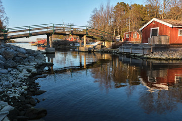 Fototapeta premium Small bridge over a river with red cabin on the other side