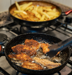 Making chicken schnitzel and french fries in the home kitchen