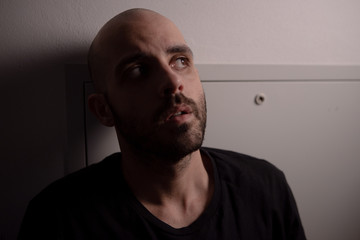 Fototapeta premium Segregated man going crazy. Segregation and isolation concept. Man in Quarantine. Depression concept. Caucasian depressed man. Low light key