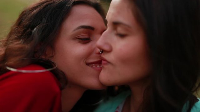 Young millennial lesbian LGBT couple in loving relationship kissing and dating