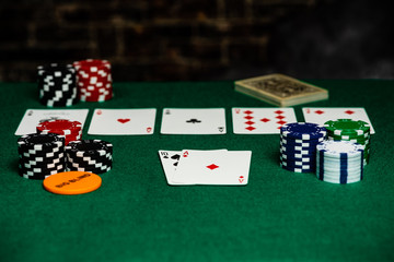 4 aces in Texas Hold-em on a green felt playing surface surrounded by betting chips and a big blind chip.  Bright foreground with a fast falloff to the back.  Room for Copy