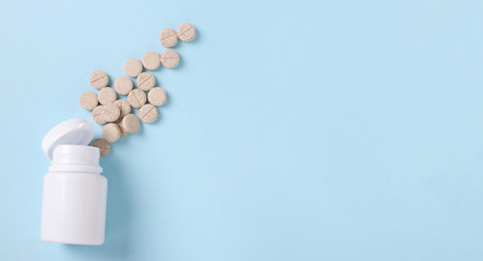 Homeopathic cough pills mucaltin in a jar on a blue background, Copy space