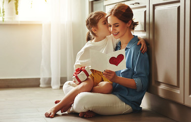 Little girl giving card to mom.