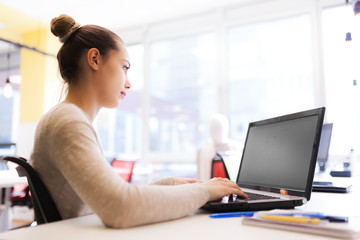 Beautiful girl working on a laptop in a modern coworking space. Successful businesswoman in an office.