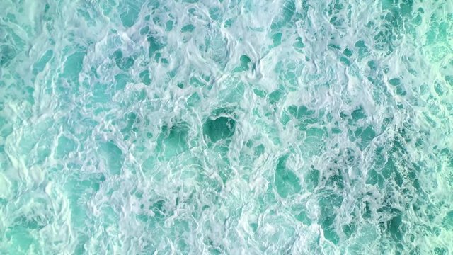 Aerial top down view of ocean waves crashing and foaming. Bali, Indonesia.