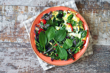 Plate with scrambled eggs with spinach and vegetables. Healthy food. Keto diet.
