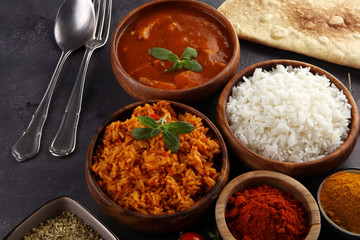 Chicken tikka masala spicy curry meat food in pot with rice and naan bread. indian food on table