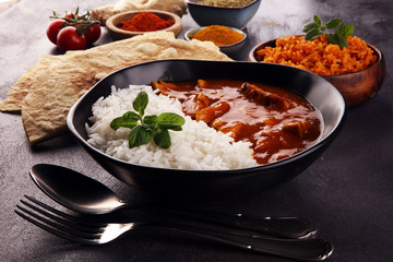 Chicken tikka masala spicy curry meat food in pot with rice and naan bread. indian food on table