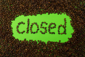 The word closed is laid out on green paper with coffee grains. business concept.