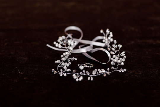 Bride's accessory. white gold engagement ring with diamond and hair accessories on black background. selective focus