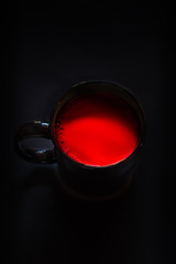 taza negra en un fondo negro con liquido rojo