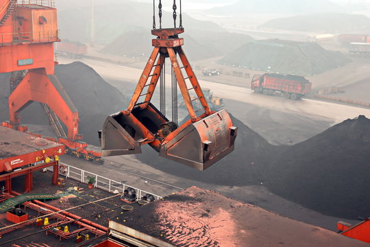 Cargo terminal for discharging coal cargos by shore cranes during foggy weather. Port Bayuquan,China. January, 2020.