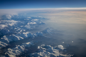 View from a cockpit of a commercial airliner airplane over a beautiful mountain range