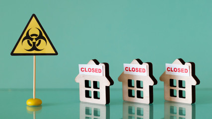 Biohazard symbol and wooden houses with the inscription closed. Concept of quarantine in the...