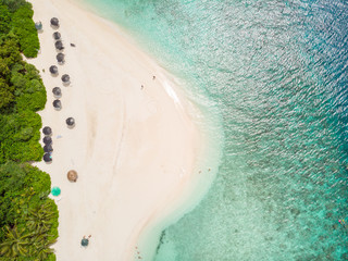 Aerial drone view of picture perfect beach and turquoise lagoon on small tropical island on Maldives.