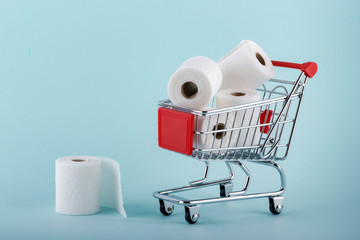 Toilet paper rolls in shopping trolley. Panic about coronavirus covid-19. People are stocking up essentials for home quarantine.