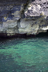 turquoise sea and rocky cliff. vertical photo