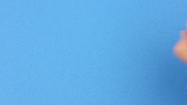 gold yellow jewelry chain falls on blue table, human hand grabs or takes it, pawnshop or concept of investment in gold or theft crime, close up view