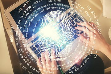 Double exposure of woman hands working on computer and fingerprint hologram drawing. Top View....