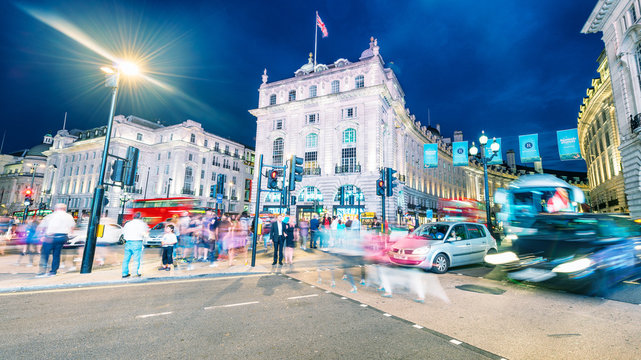 LONDON - JULY 3, 2015: Piccadilly Circus and Regent Street traffic with tourists at night. City lights