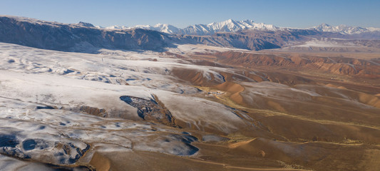 aerial landscape of the amazing Ozero Torpo, a lake surrounded by eroded mud hills along the Mels-Ashu pass connection Tash-Rabat at the village of Baetov