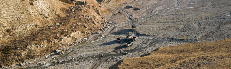 aerial image showing trucks traffic coming from the coal mine crossing the river bed in the Arpa valle