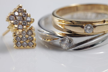 Close up shot of fine gold jewellry set that consist of earrings and marriage / wedding rings