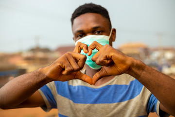 young handsome african nigerian man wore face mask preventing, prevent, prevented himself from the...