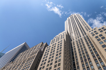 Fototapeta na wymiar Skyscrapers of Manhattan, giant wall with blue sky