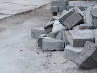A pile of stone tiles on the street in the city, reconstruction sidewalk site