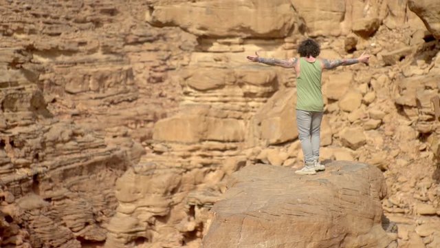 A guy dancing in a canyon, moving stylishly, travels, heat, Sahara